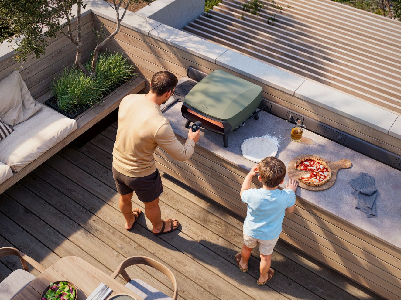 Widok na taras z góry, na którym tata z synem przygotowują piec do wypieku