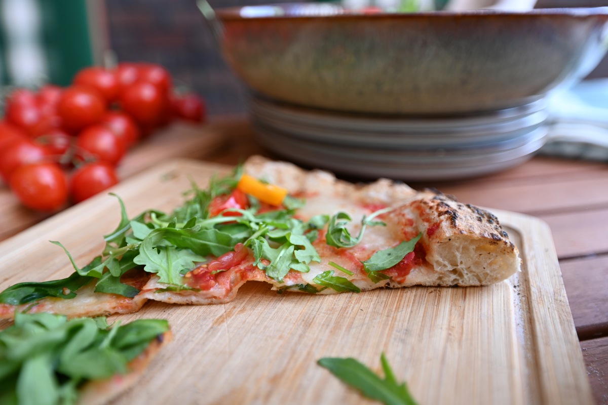 Widok na przekrój kawałka pizzy z charakterystyczną napowietrzoną strukturą brzegów